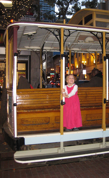 Modest clothing on an adorable child riding a San Francisco cable car!